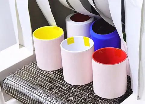 Put the mugs into the tunnel oven